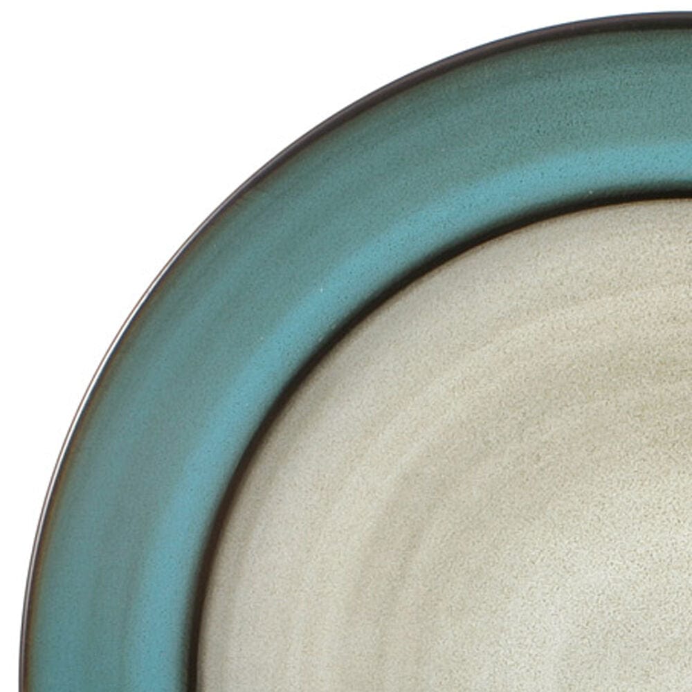 A mug from the Song Bird dinnerware collection sitting next to a steaming cup of coffee, emphasizing everyday use