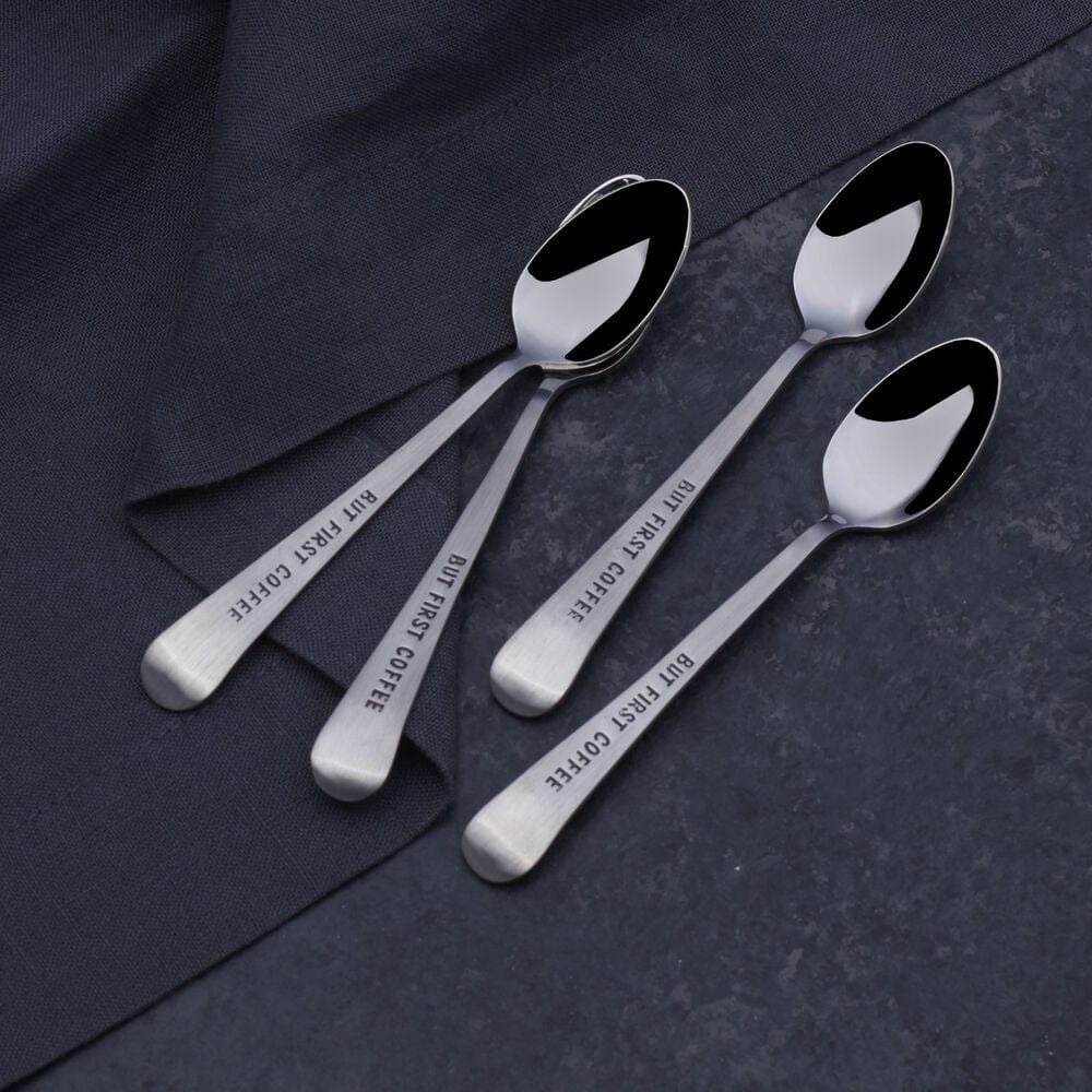 Close-up of the But First Coffee mini spoon showing its stainless steel finish and stamped design.