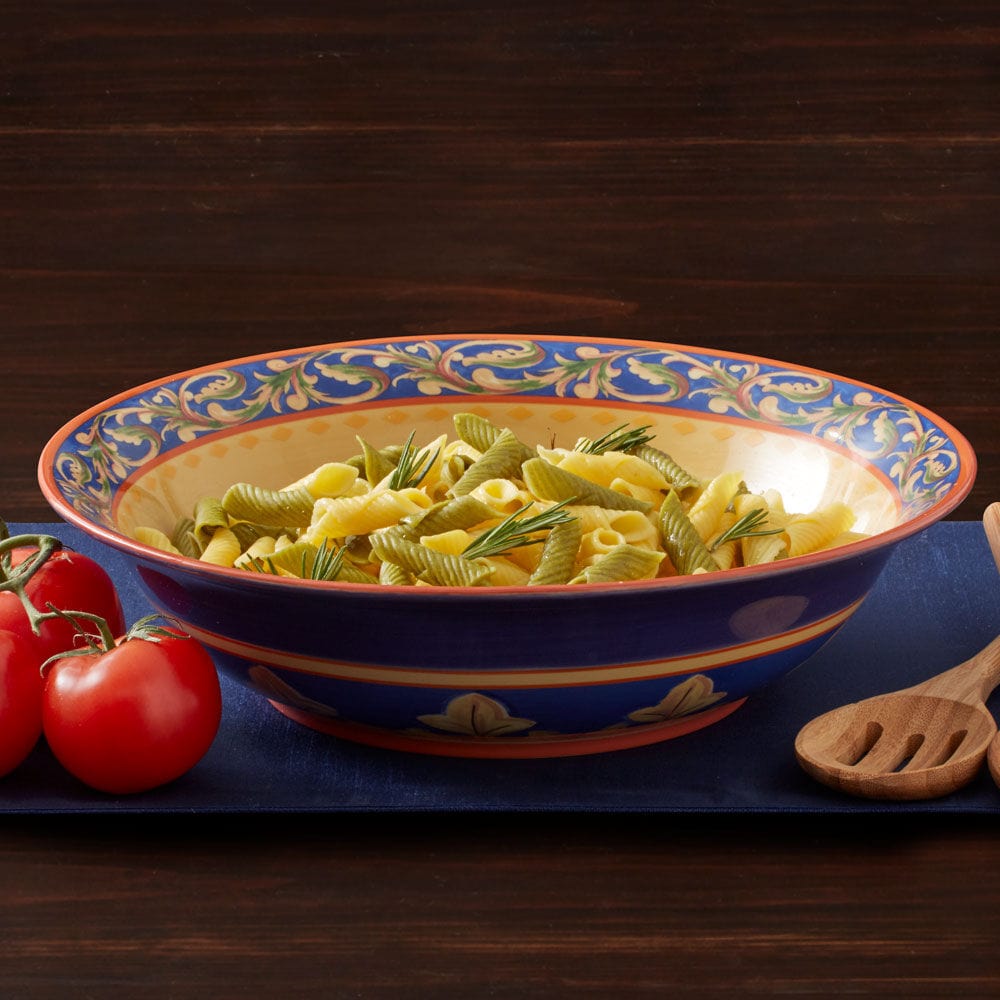 Large stoneware pasta serve bowl filled with spaghetti on a dining table