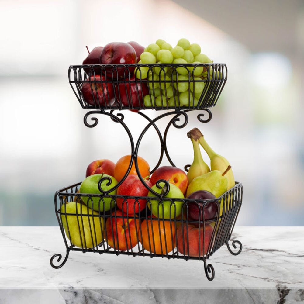 Rustic two-tier fruit basket against a kitchen wall, filled with fresh fruits.