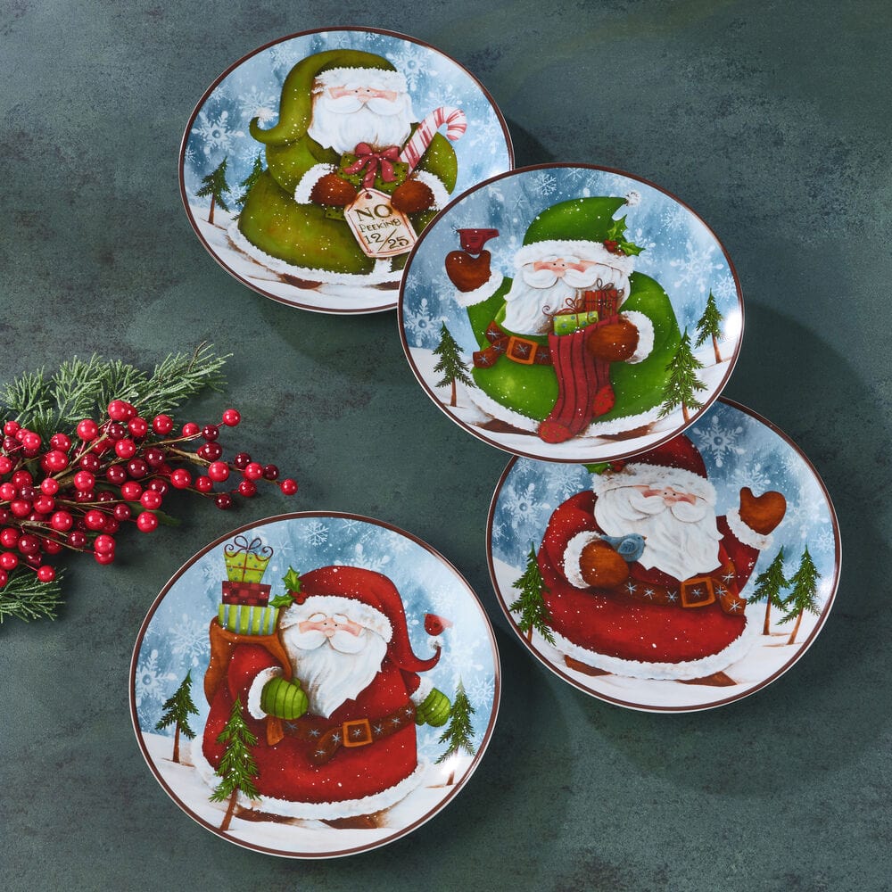 Overhead view of four Santa salad plates arranged on a holiday table with festive napkins