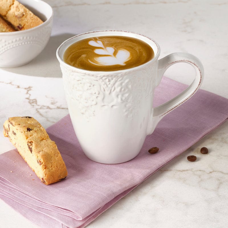 Front view of a set of 4 white stoneware coffee mugs with lace pattern