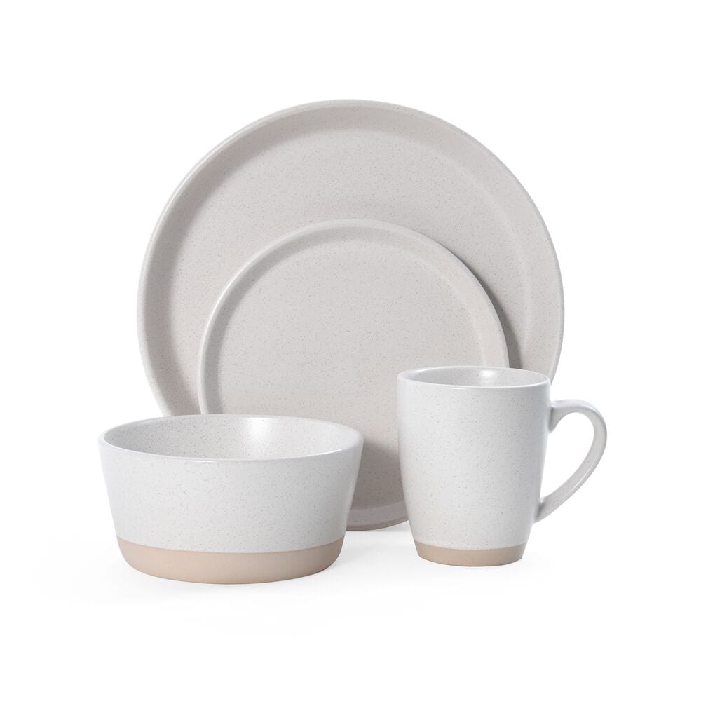 Elegant beige stoneware dinner plates set on a dining table, showcasing the unique coupe shape.