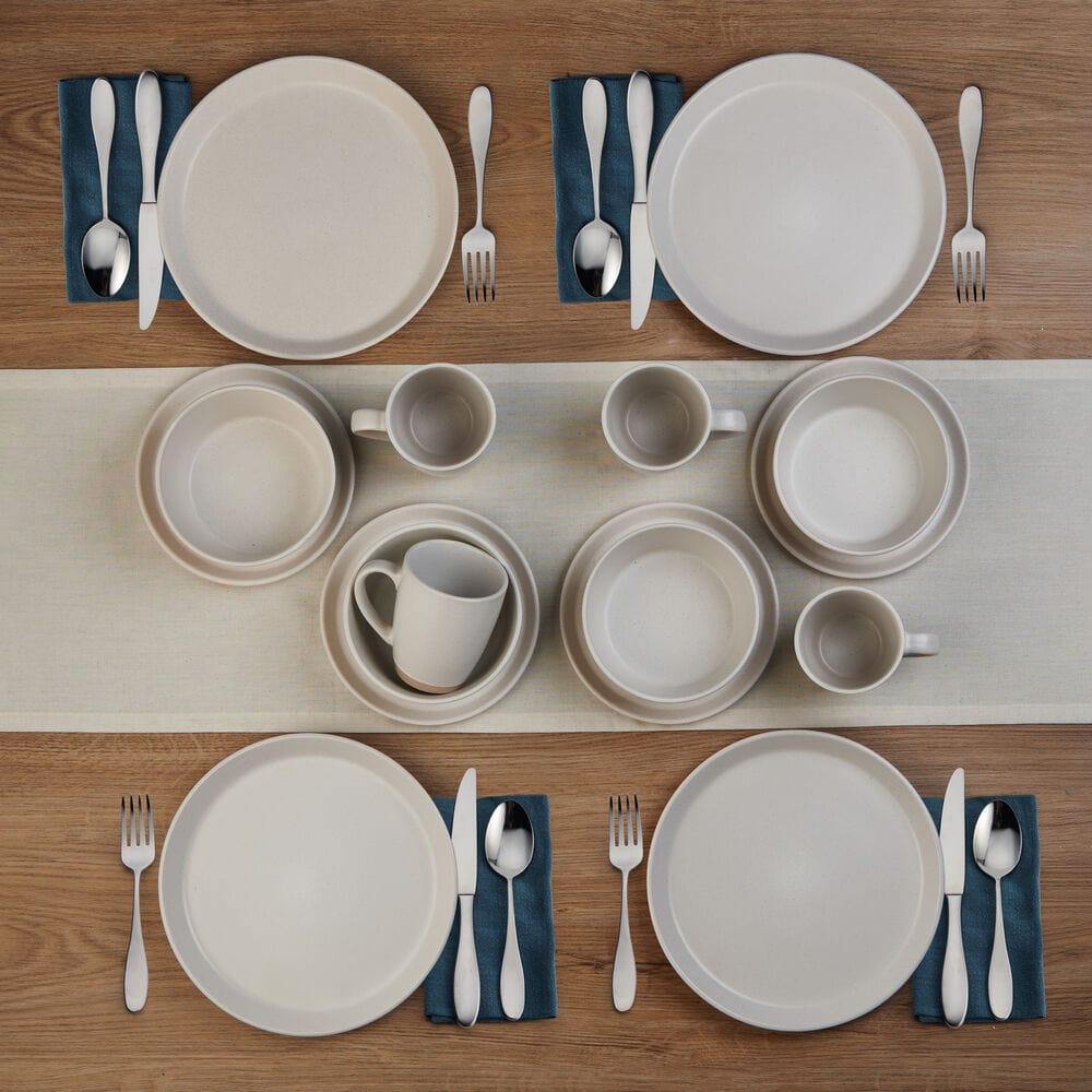 Elegant beige stoneware dinner plates set on a dining table, showcasing the unique coupe shape.