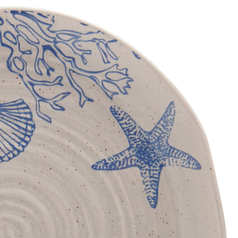 Close-up of rustic stoneware dinnerware set with aquatic pattern, showcasing organic shapes and speckled finish