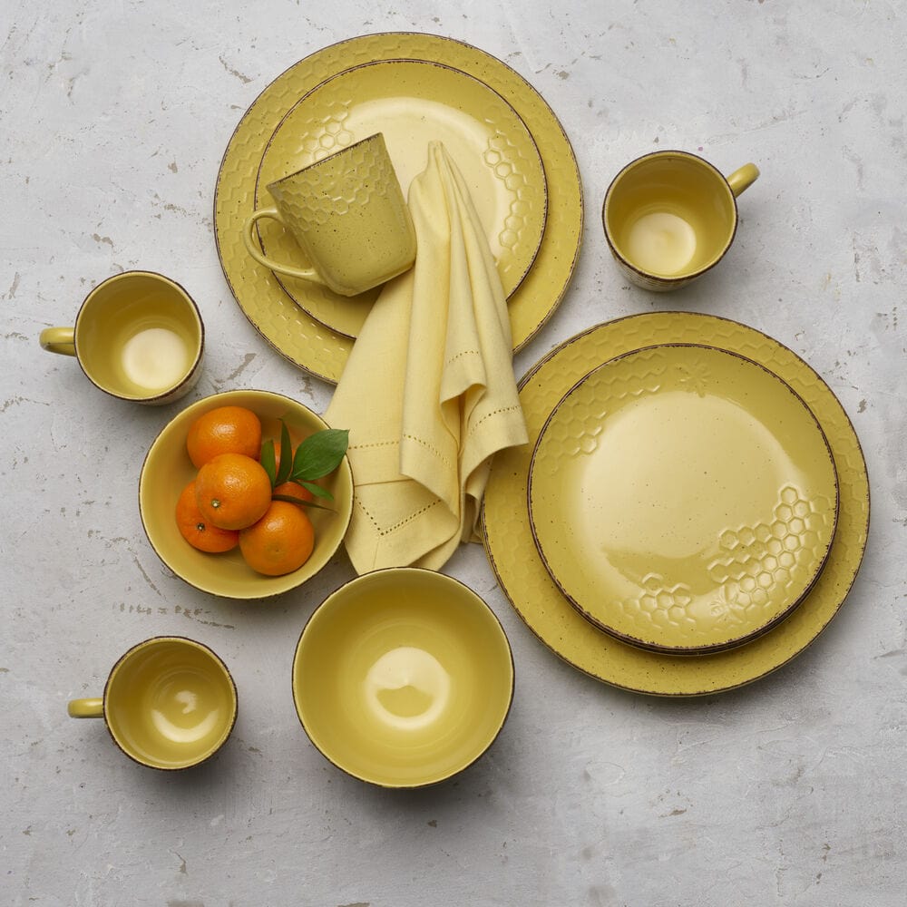 Sunny Honeycomb dinnerware set displayed on a dining table, showcasing dinner plates and bowls.