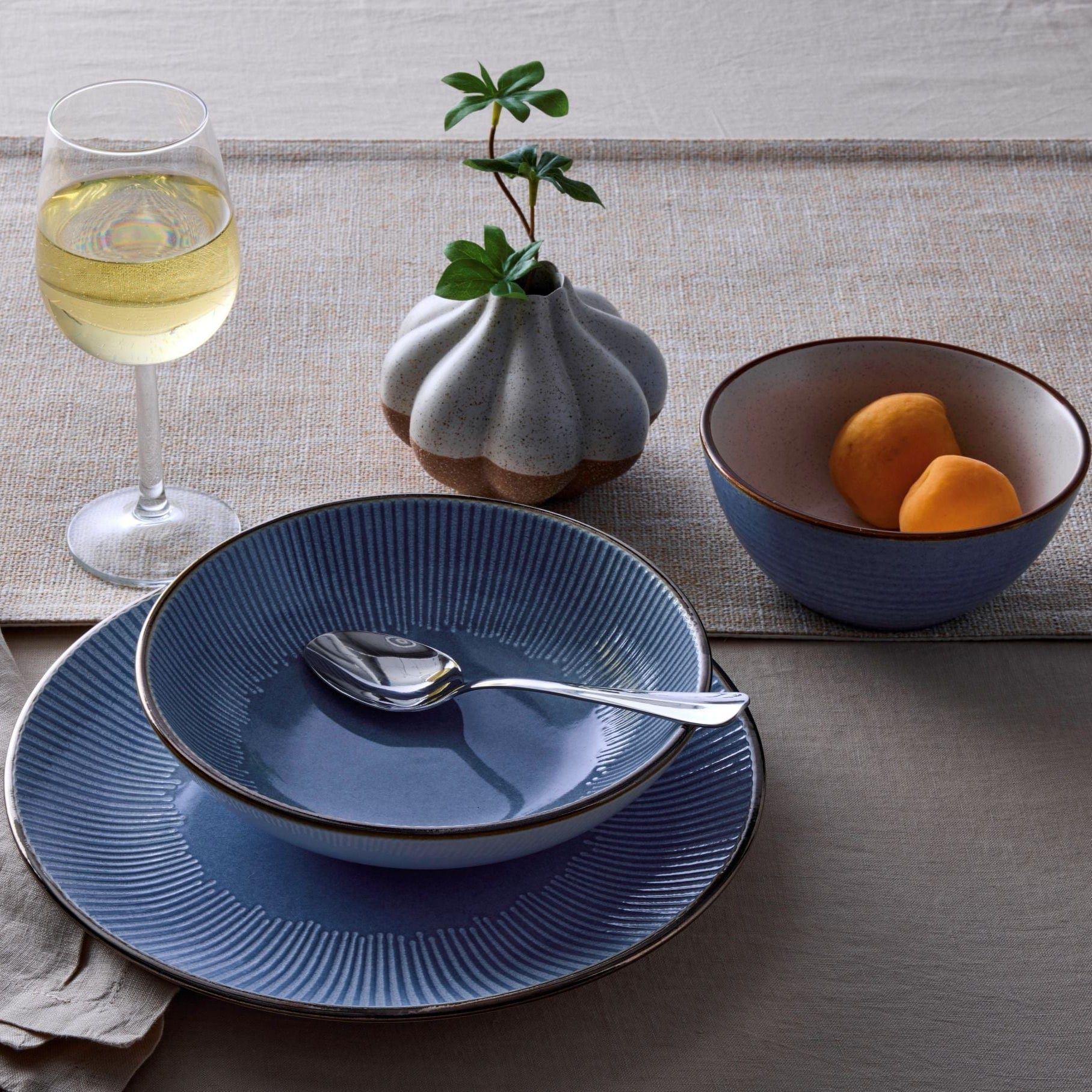 Close-up of embossed blue dinner plates with metallic rim detail