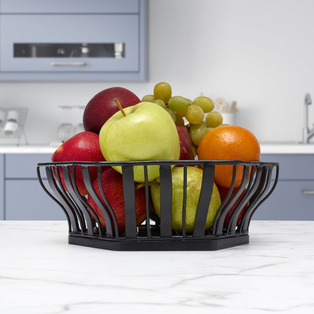 Elegant hexagonal fruit basket showcasing fresh fruits on a dining table.