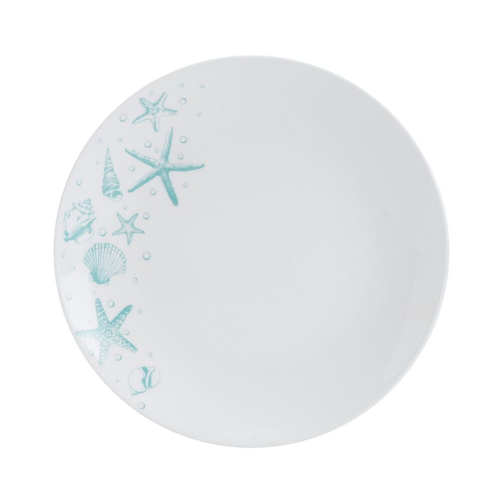 Whimsical ocean blue dinnerware set with starfish and seashells on a dining table