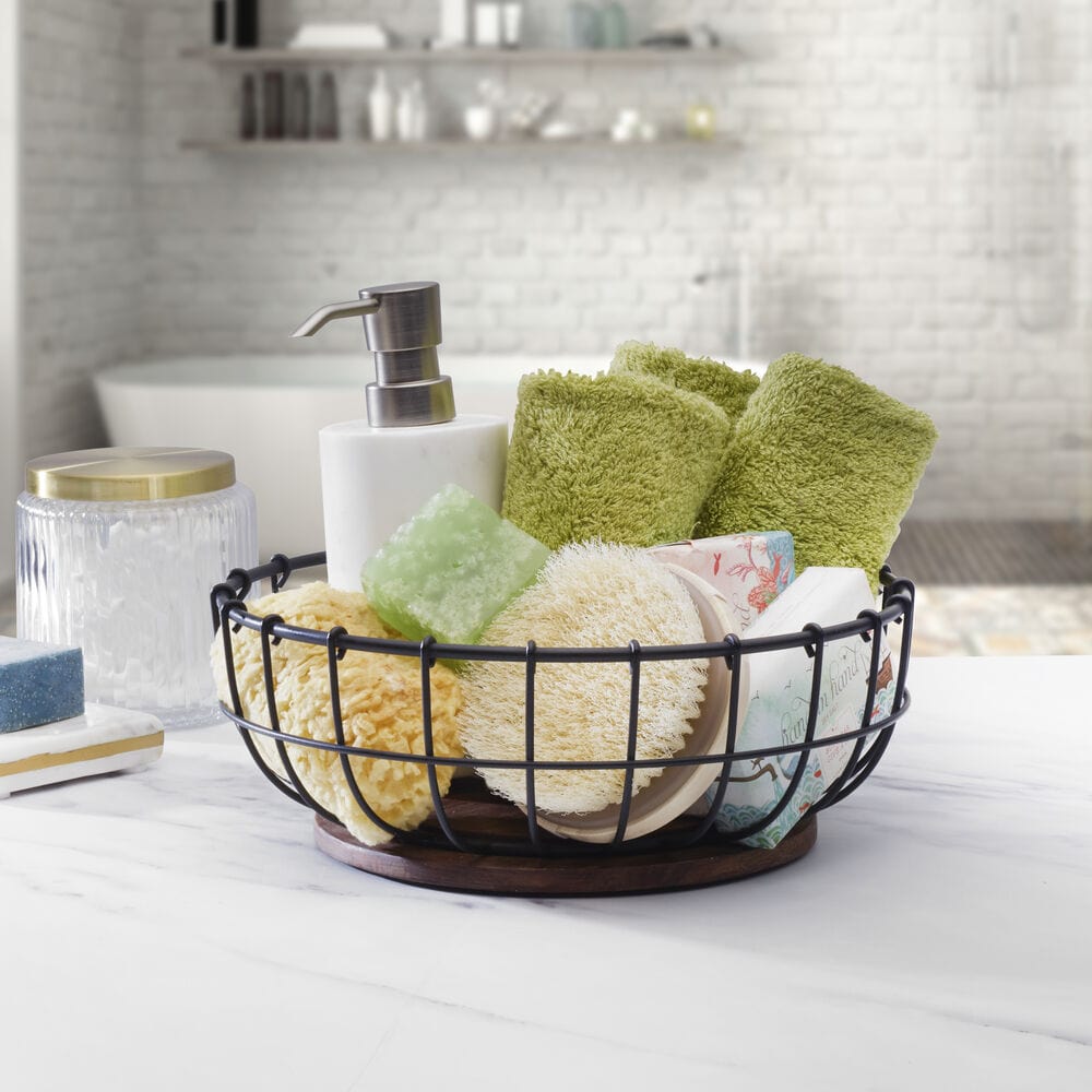 Elegant wire cage centerpiece basket showcasing fresh fruits on a dining table.