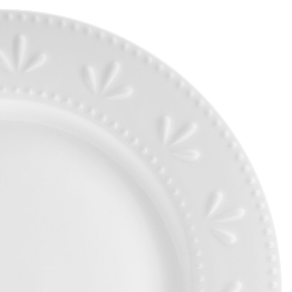 Dining table set with Maddy porcelain dinnerware, including plates and bowls with embossed design