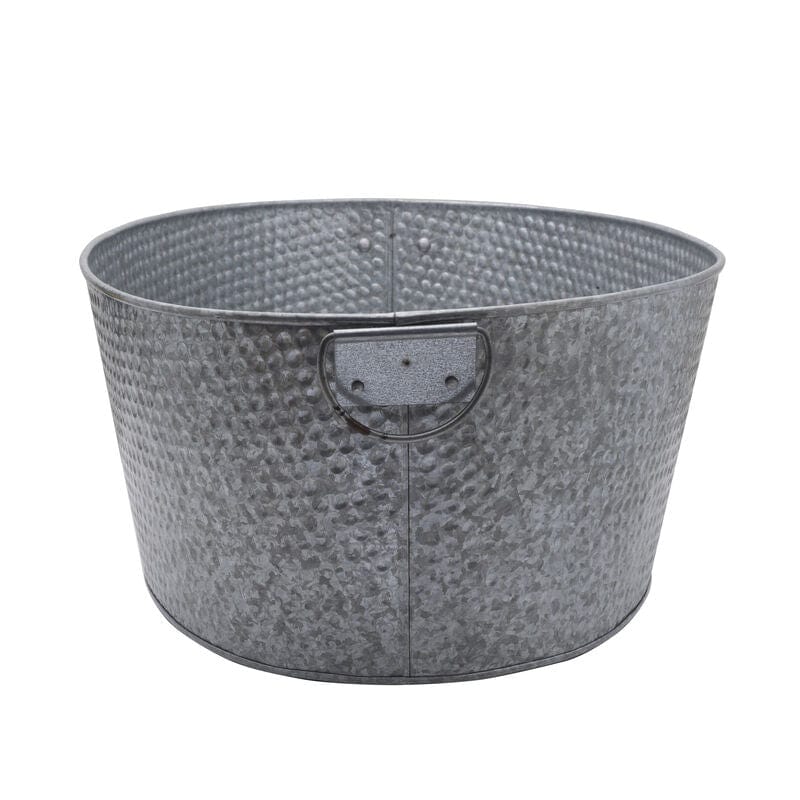 Large galvanized metal beverage tub filled with ice and drinks at a backyard BBQ.