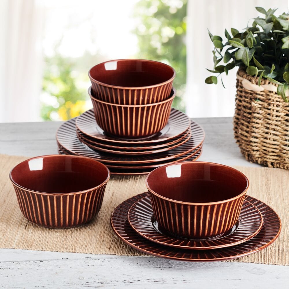 Red stoneware dinnerware set with embossed pattern on dining table