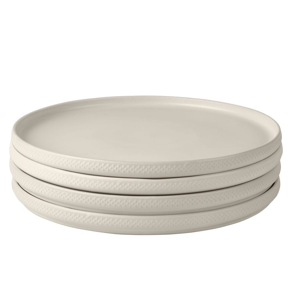Set of 4 oyster white dinner plates arranged on a table