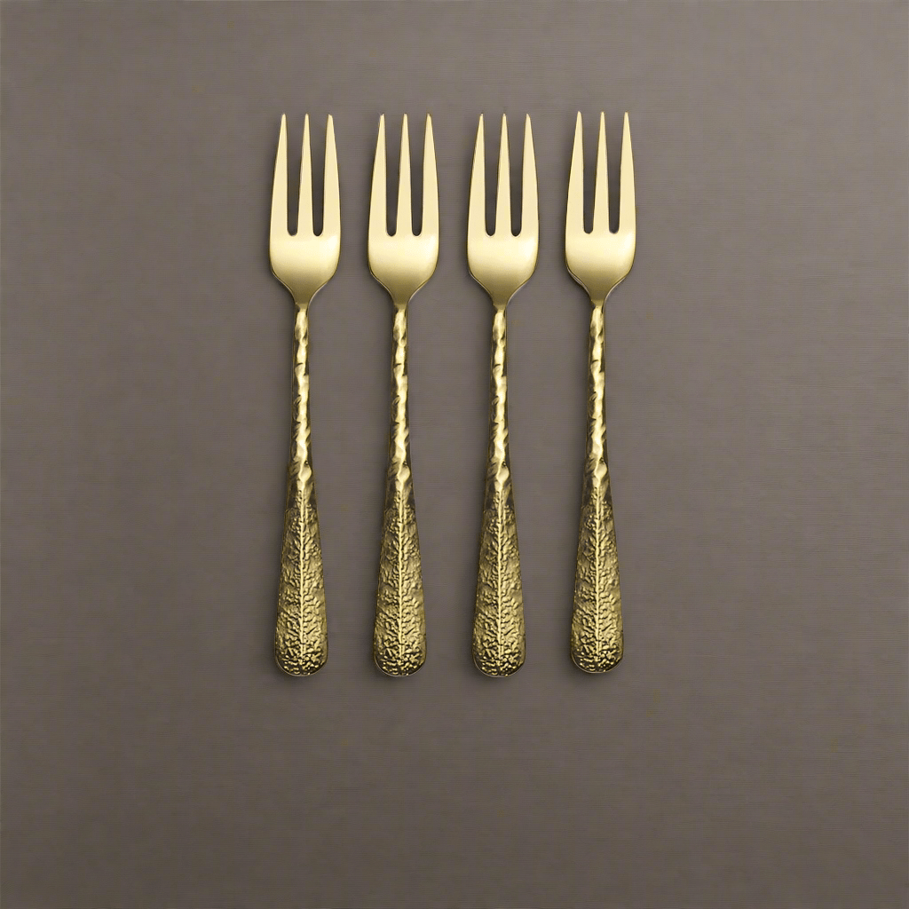 Close-up of gold appetizer forks with hammered texture for elegant serving