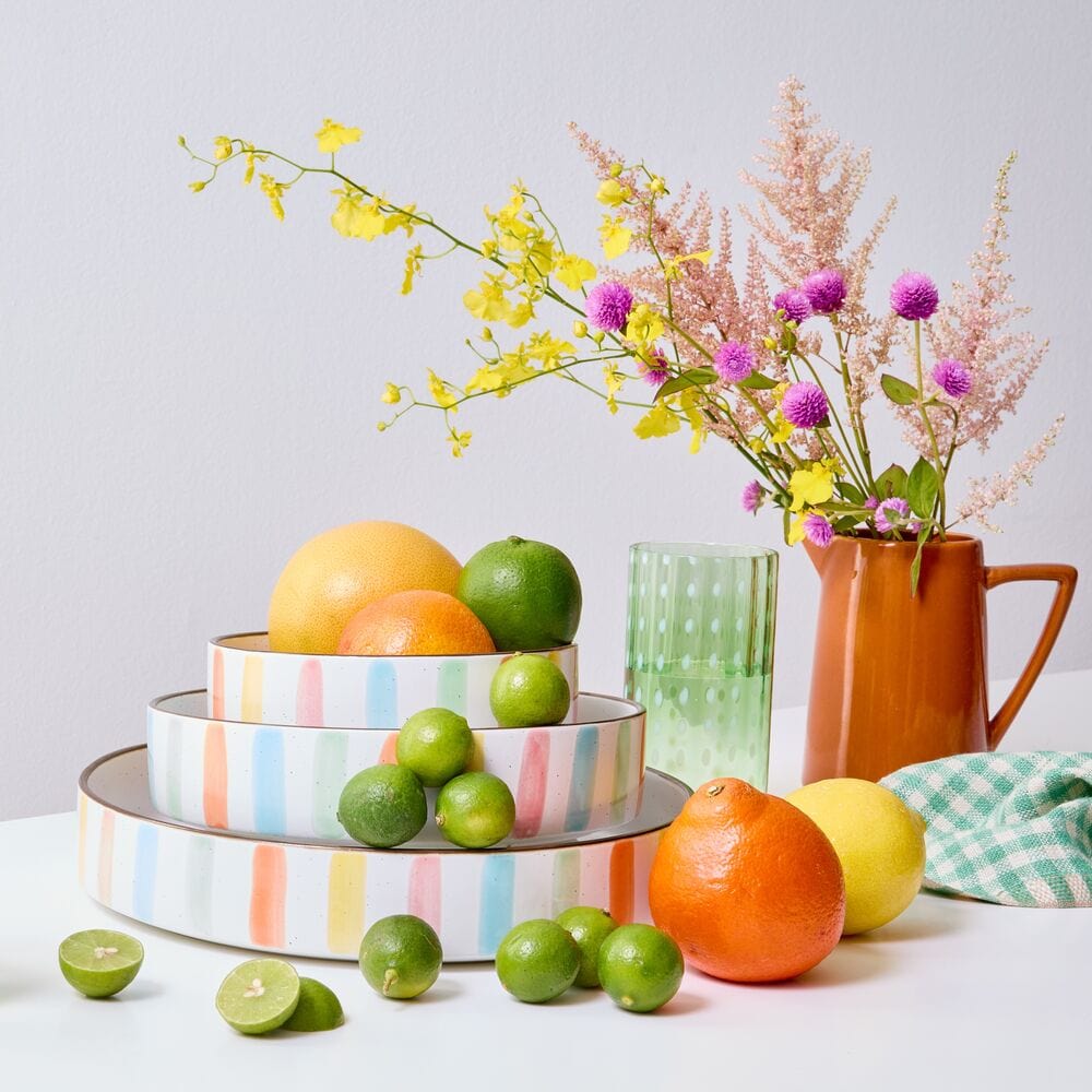 Colorful summer stoneware bowls arranged on a table for entertaining