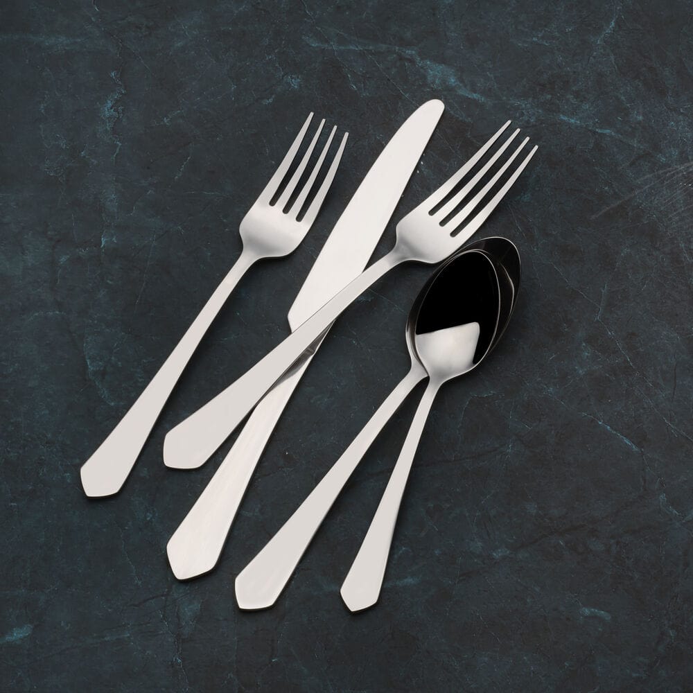 Elegant Almond 20-piece stainless steel silverware set arranged on a rustic table.