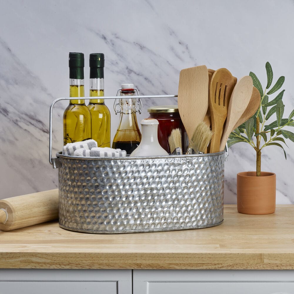 Galvanized metal caddy with utensils and condiments in outdoor setting
