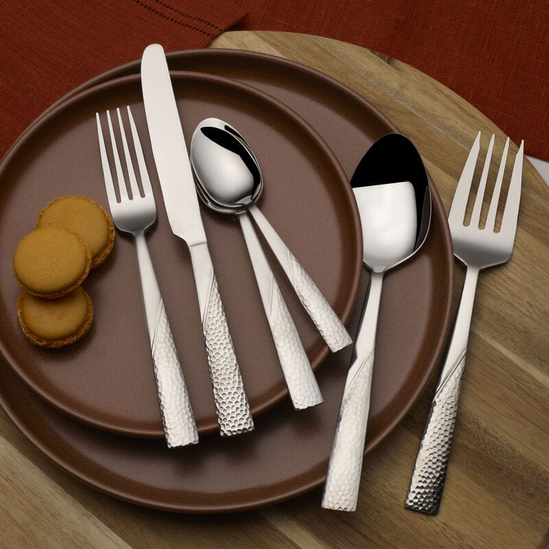 Serving utensils from the Loring flatware set in use during a family dinner, emphasizing its practicality and stylish appearance.