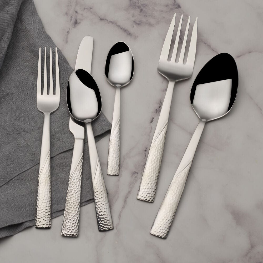 Loring 34-piece stainless steel flatware set displayed on a dining table, showcasing its modern finish and elegant design.