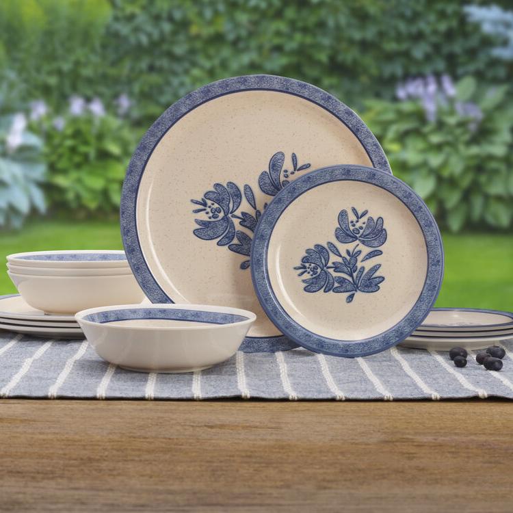 Yorktowne outdoor melamine dinnerware set displayed on a picnic table, featuring dinner and salad plates with vibrant colors.