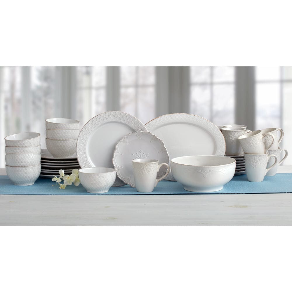 Flat lay of white stoneware dinnerware set with serving bowls and platter