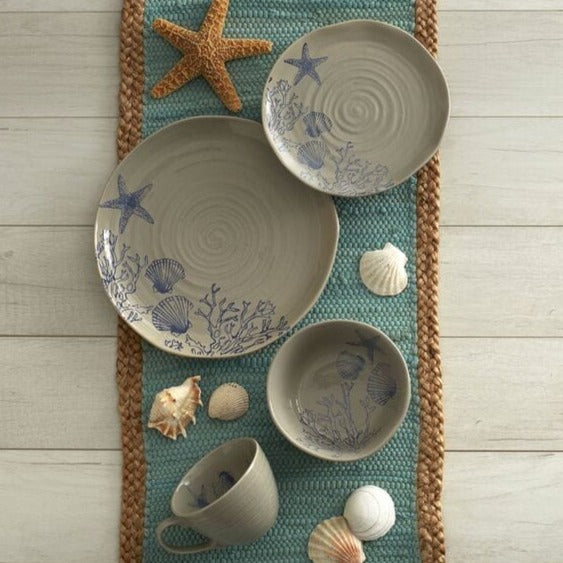 Close-up of rustic stoneware dinnerware set with aquatic pattern, showcasing organic shapes and speckled finish