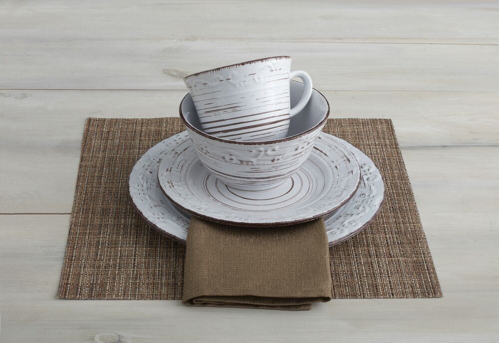 Set of four white salad plates stacked, demonstrating their practical and stylish design.