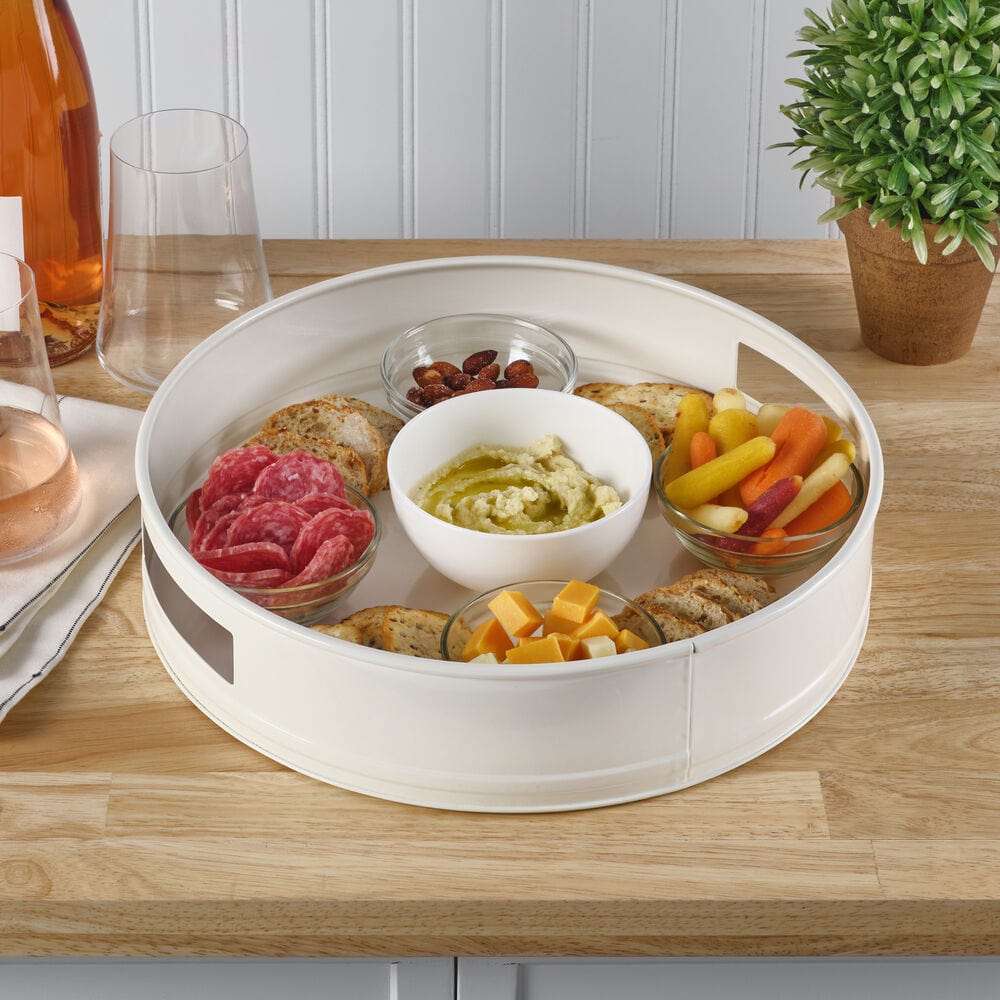 Elegant round metal serving tray showcasing appetizers at a party.