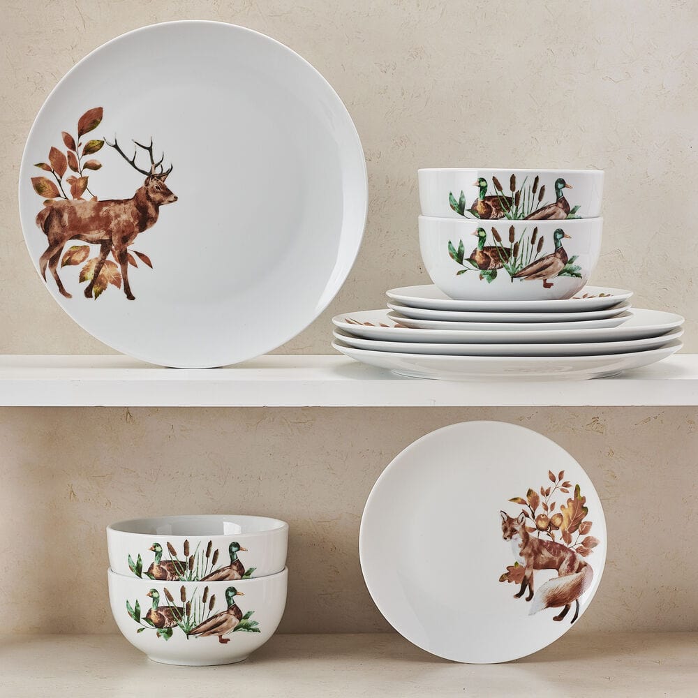 Close-up of woodland animal ceramic dinnerware set for 4 on a rustic table