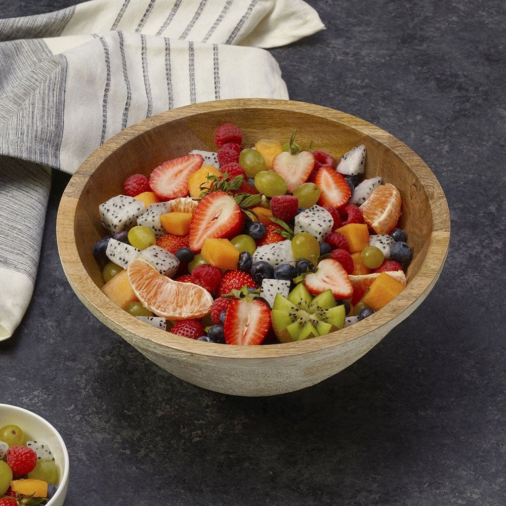 Elegant mango wood bowl on a dining table with various dishes