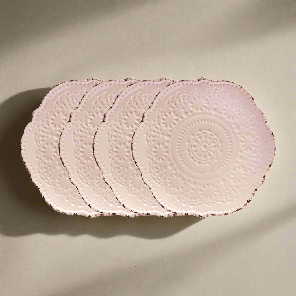 Chic pink salad plates showcasing intricate lace patterns and scalloped edges, perfect for serving salads.