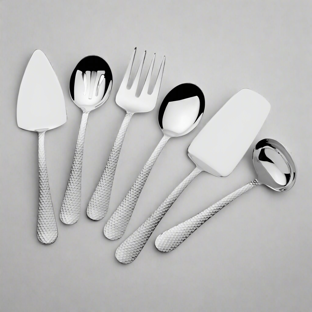 Close-up of stainless steel serving set with utensils arranged for serving salads and desserts