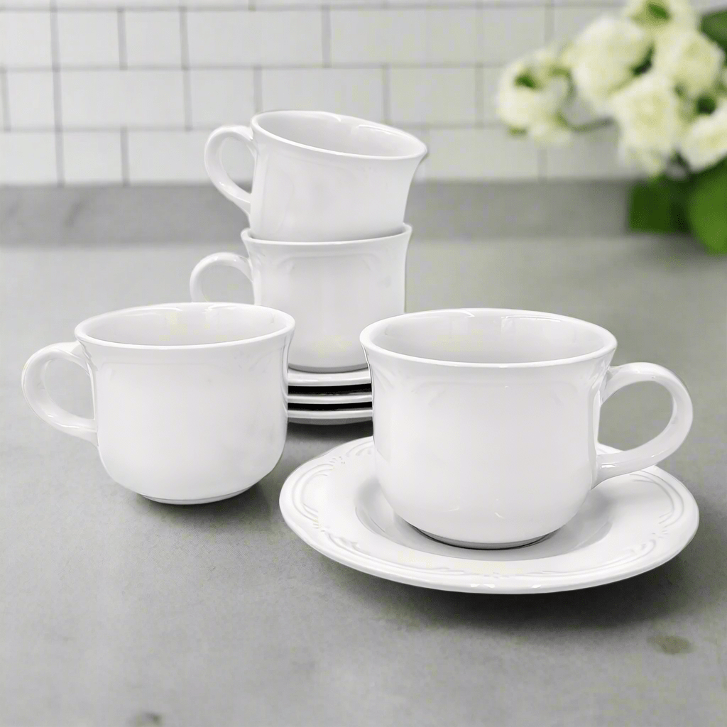 Elegant stoneware tea cup and saucer set with embossed design on a table setting.