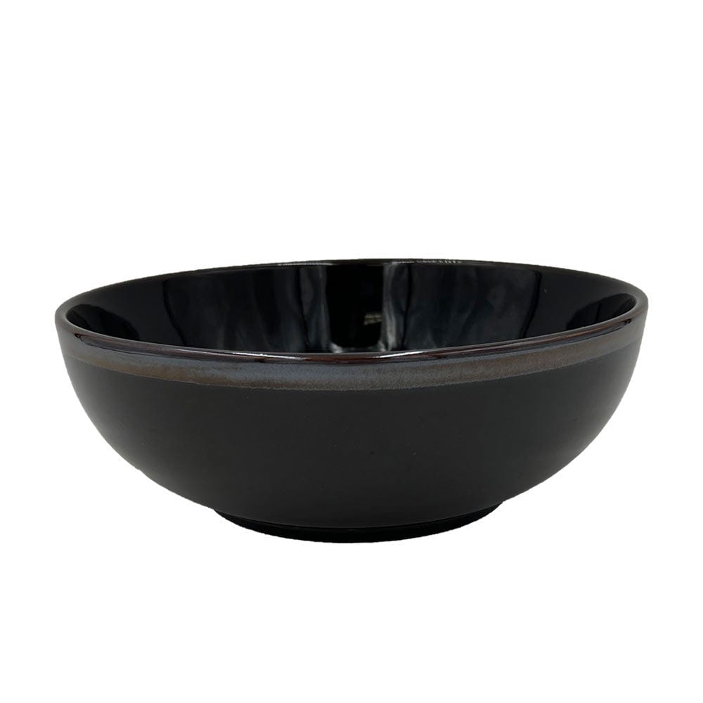 Side angle of the Jade Serve Bowl on a dining table, demonstrating its size and unique glaze.