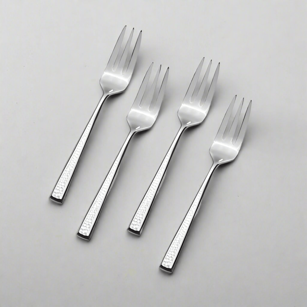 Mea set of 4 stainless steel appetizer forks elegantly displayed on a dining table