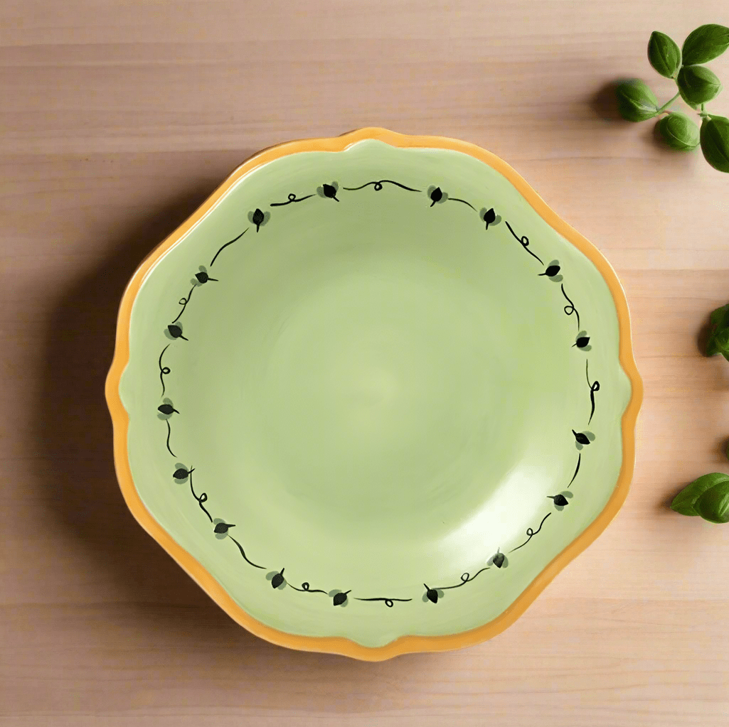 Pistoulet Stoneware Salad Plate with yellow band displayed on a dining table, perfect for serving salads.
