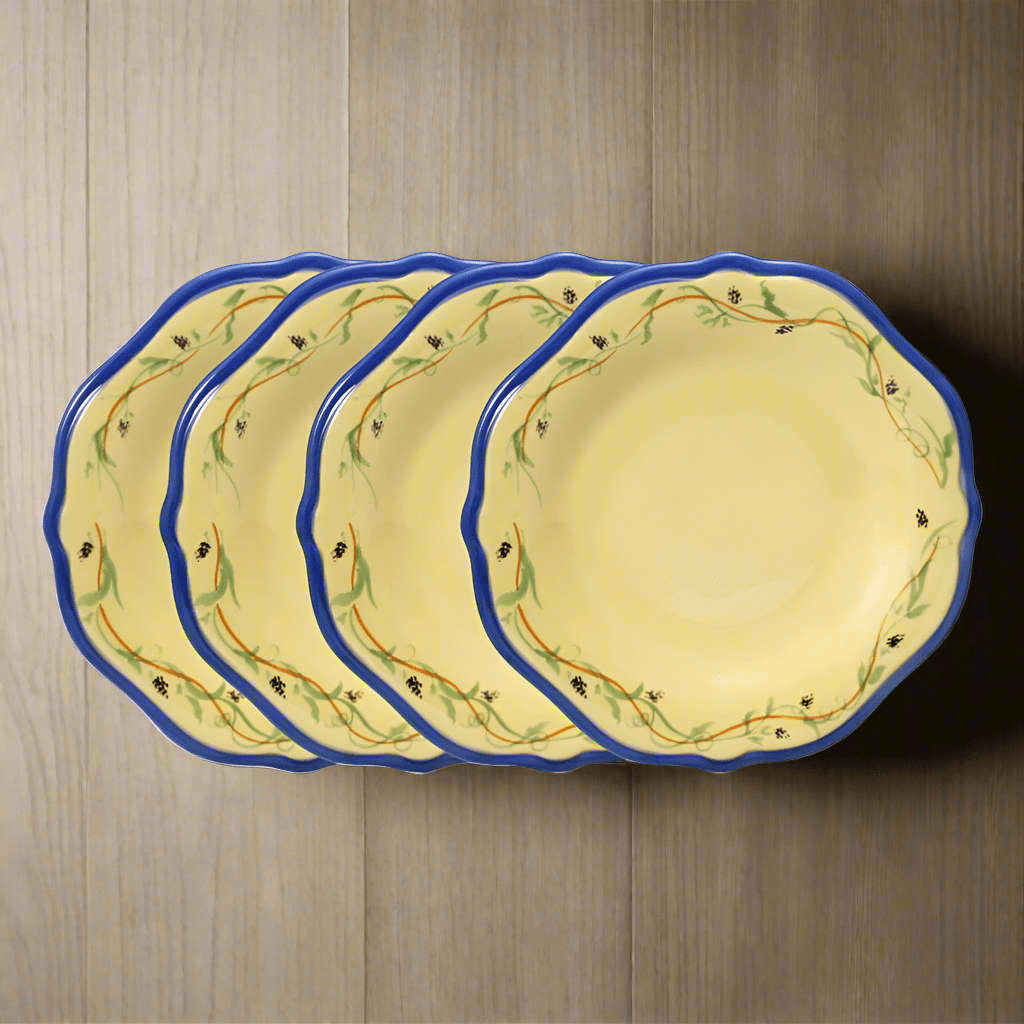 Overhead view of Pistoulet stoneware salad plates with blue band, arranged on a rustic wooden table