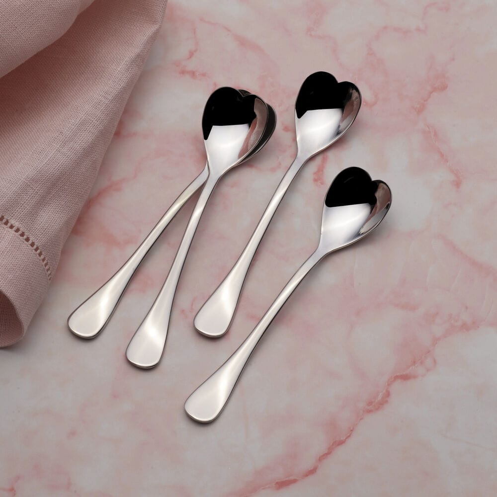 Close-up of mini heart-shaped coffee spoons with shiny stainless steel finish
