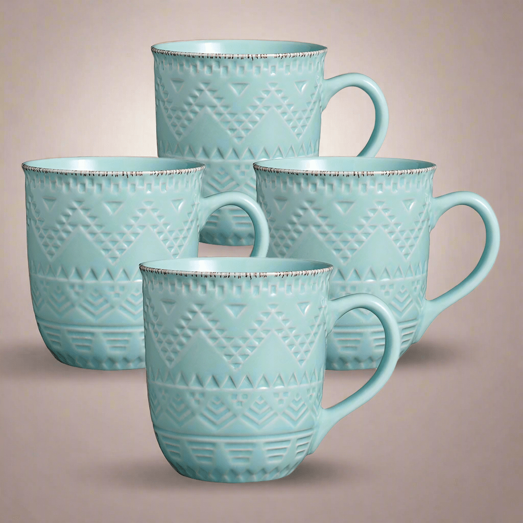 Front view of the teal ceramic mugs showcasing their intricate embossed patterns.