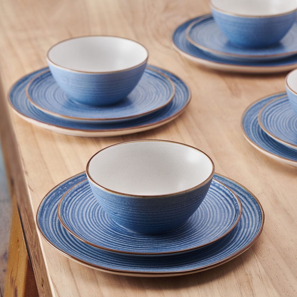Rowan Blue dinner plates featuring concentric circles and a warm tan rim from an overhead angle