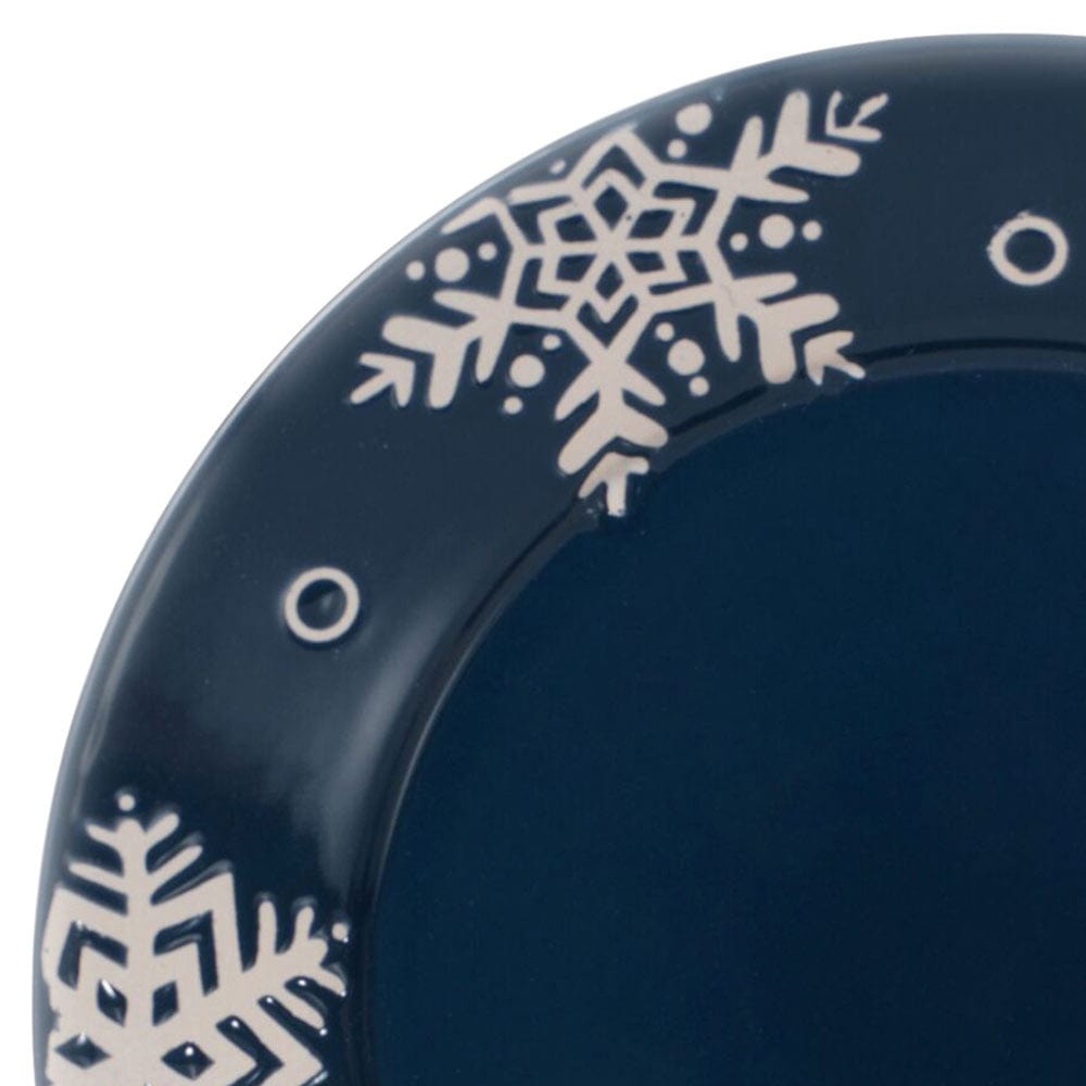 Close-up of blue and white stoneware dinner plate with snowflake pattern, ideal for holiday tables