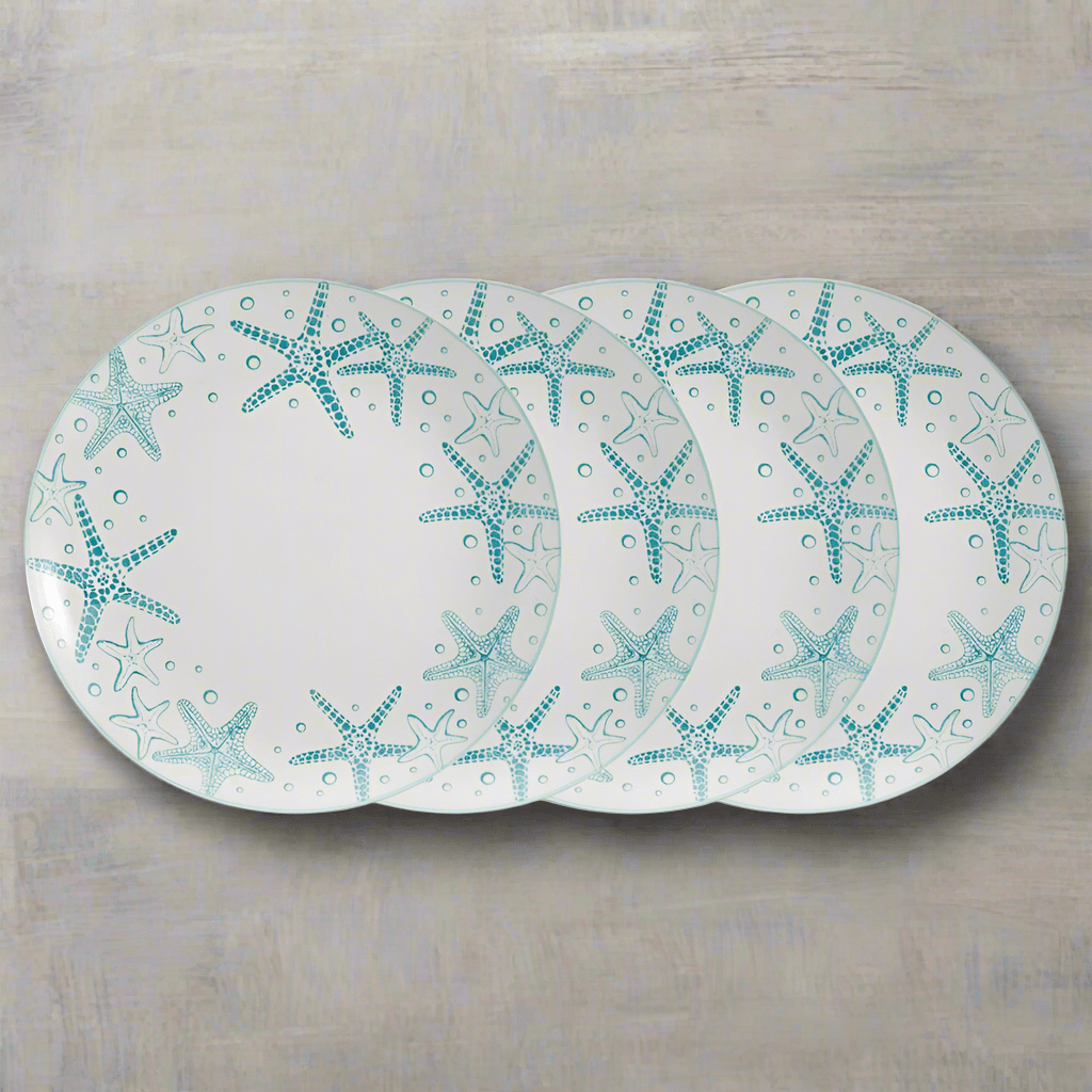 Close-up of whimsical seashell dinner plates showcasing starfish designs on a summer table.