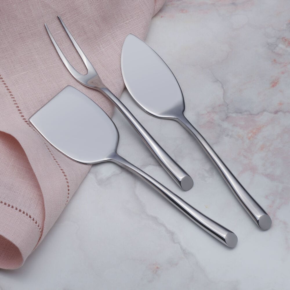 Modern stainless steel cheese knife and fork on cheese board