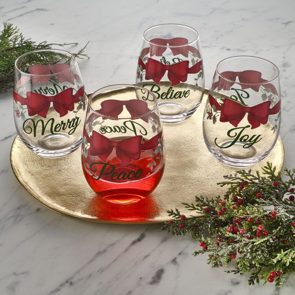 The complete set of four Winterberry stemless wine glasses elegantly arranged on a table.