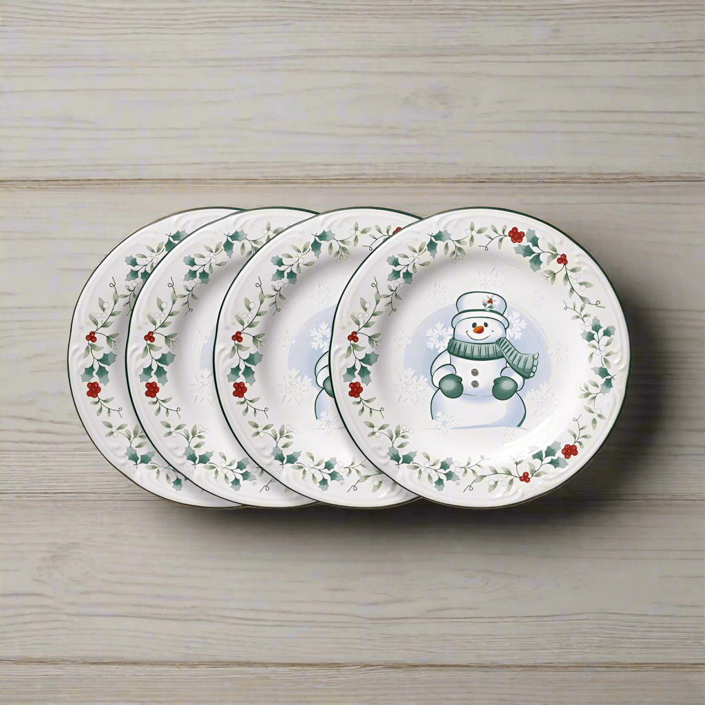 Close-up of snowman salad plates with Winterberry pattern on a holiday table