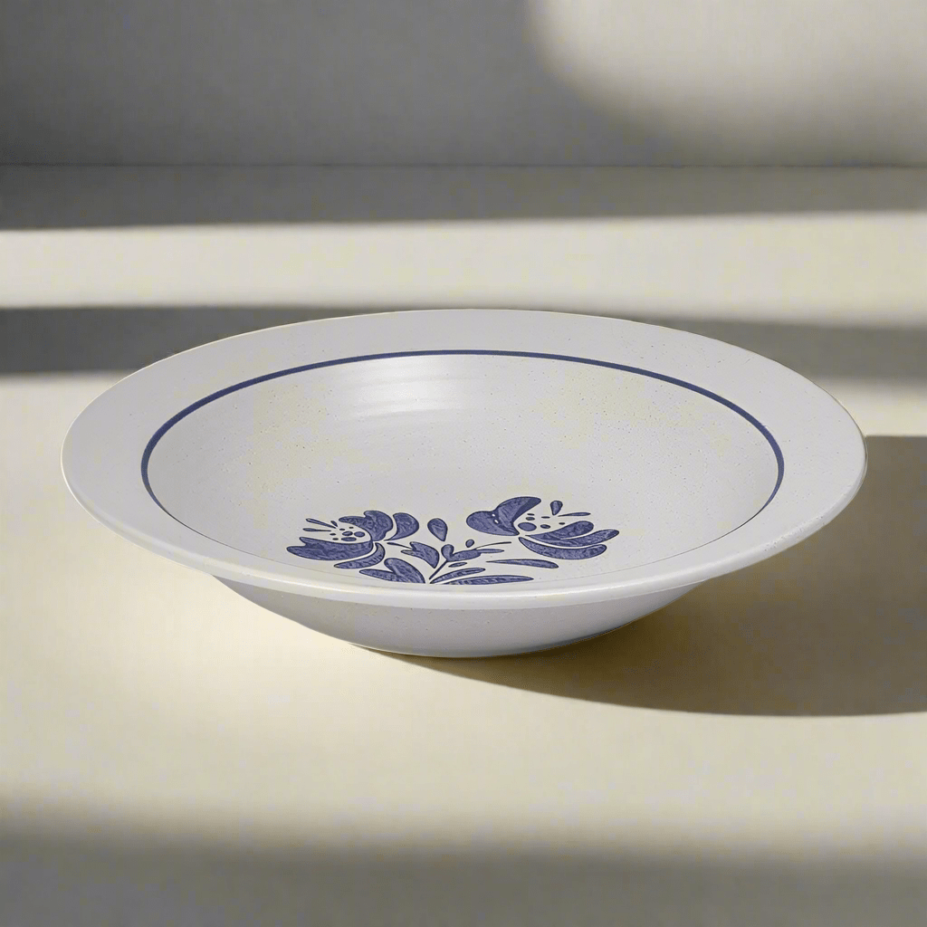 Close-up of stoneware pasta bowl with pasta and sauce, highlighting its wide rim and shallow shape