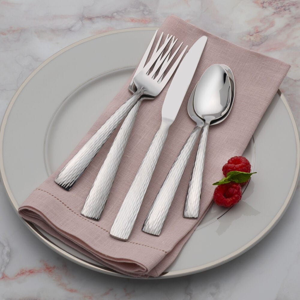 Close-up of stainless steel flatware with hammered handle design, suitable for modern tables