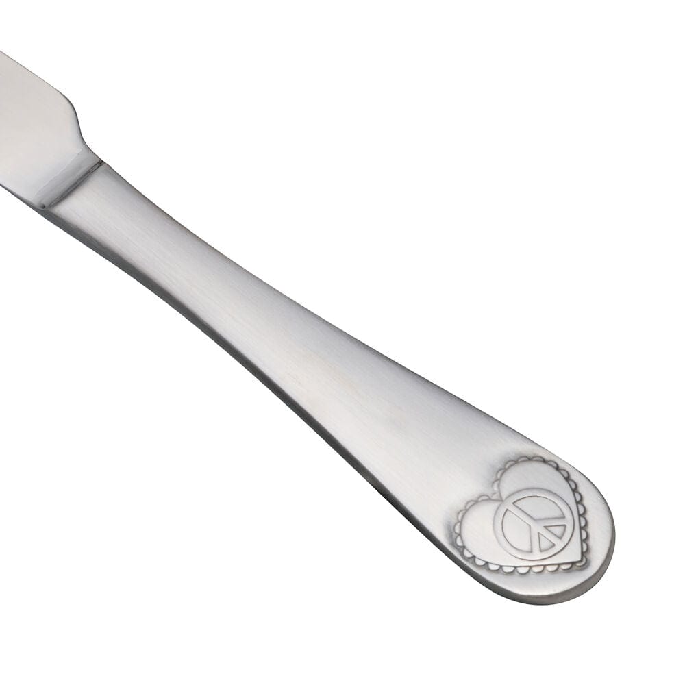 Close-up of stainless steel flatware set with peace sign handles, arranged for a dinner setting