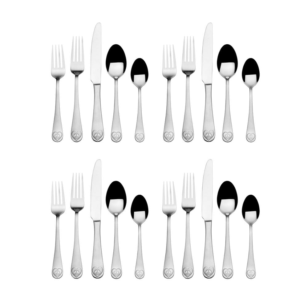 Close-up of stainless steel flatware set with peace sign handles, arranged for a dinner setting
